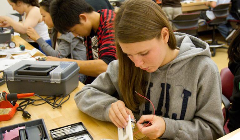 Students works on electronic project at workbench